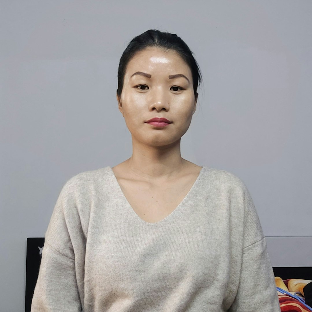 一位东亚女性客户的正面肖像照，肤色匀净，发丝柔顺，光线柔和，神情温和